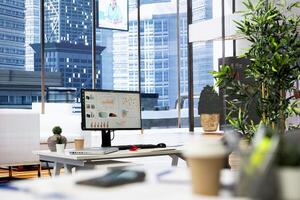 Empty financial department with stock portfolio on computer screen and paperwork files filled with marketing charts. Forex exchange indices on PC device monitor in bright modern office photo