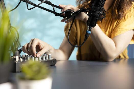 Content creator checking mic is properly calibrated, ensuring it captures clear audio for upcoming . Close up of influencer checking audio levels, making adjustments to balance sound photo