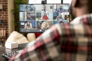 Self employed man conducting online business meeting from home, presenting startup pitch and financial report to remote investors. Black male employee attends diverse virtual webinar session. photo