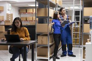 Asian team of workers in a depot checking the packages for shipment logistics, overseeing express delivery for orders. Staff focusing on growing the local brand small business. photo