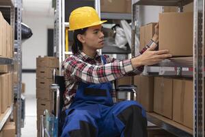 Asian employee with physical impairment processing parcels for local delivery, checking inventory and packages on depot racks. Storage room and shelves designed for accessibility. photo