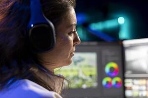 Videographer in media agency wearing headphones, ready to start color correcting raw footage, close up. editor editing renders, using software to make montage from clips, listening music photo