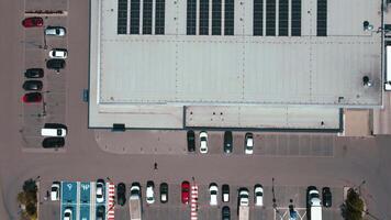 Aerial view of store parking lot with cars and rooftop solar panels video