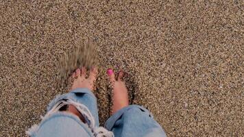 Waves crashing splashing female legs with pink pedicure on sandy beach seashore in Antalya Turkey during sunset. Sea vacation travel tourism scene concept. Tranquility and slowing down relaxing video