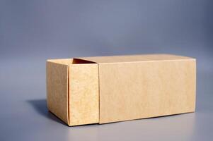 Simple open brown cardboard box on gray surface photo
