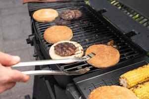 Grilling burgers and corn on outdoor barbecue grill photo