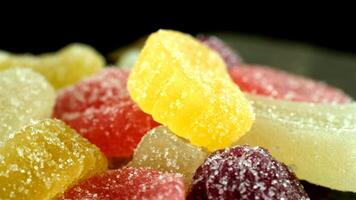 Colorful gummy candies in various shapes and sizes. The candies are coated with sugar and display vibrant colors including yellow, red, and green. video
