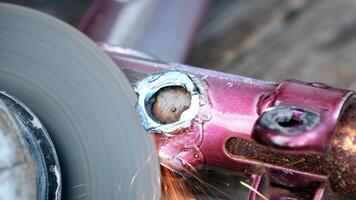 Close-up of a metal grinding process. Sparks fly from a metal surface being polished. The tool is a circular grinder, showing motion blur. video