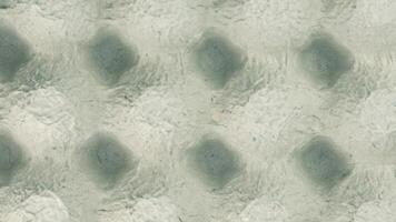 A textured gray background with a pattern of raised hexagonal shapes. The surface appears smooth with subtle variations in tone and depth. video