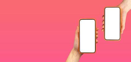 Hand holding two smartphones with app screens in pink gradient background. Mobile devices with photo