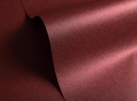 Designer paper closeup. Minimalistic red and marsala surface with pearlescent gloss, wavy folds, photo