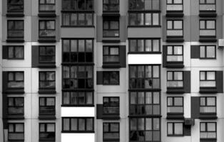 Building with black and white facade featuring windows and balconies in repeating geometric pattern. photo