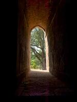 Window arch with stone frame, creating a narrow passage between light and shadow. Historic, photo