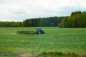 A tractor is working in a large field photo