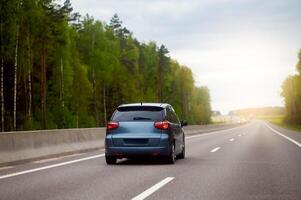 A car driving down the road in the woods photo