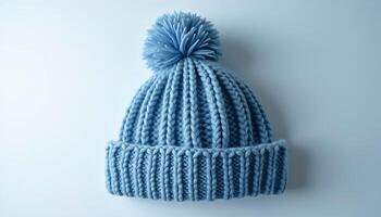 Close up of a blue knitted winter hat with pom pom on top captured in bright lighting Generated using AI photo