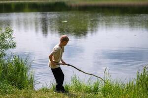 A boy is holding a stick in the water photo