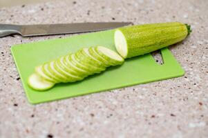 A cutting board with a zucchini on it photo