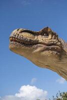 A large dinosaur statue with its mouth open photo
