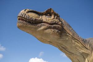 A close up of a dinosaur statue with its mouth open photo