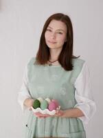 A woman in an apron holding a tray of eggs photo