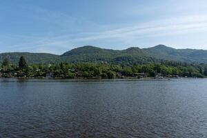 Scenic river view with lush greenery and distant hills under a clear blue sky photo