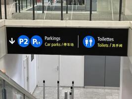 Nice, France - May 10, 2025 Directional sign indicating parking and toilet facilities in a modern building, featuring bilingual text and clear icons for easy navigation photo