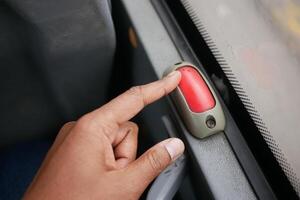 Passenger signals to stop bus with red button photo