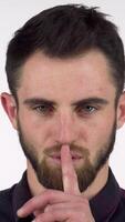 Bearded man playfully shushing the camera with a finger to his lips video