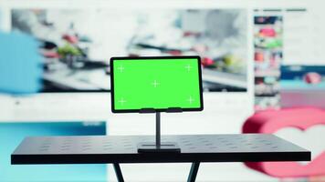 Isolated screen tablet in front of distribution service interface enabling playback anywhere. Mockup device and vibrant videowall of clips highlighting popular internet trends video