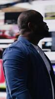 Vertical African American professional browses high tech environment with app icons, infographics and social networking feeds. Showcases big data on social media platforms, digital influence. Camera B. video