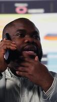 vertikal afrikansk amerikan entreprenör chattar på de telefon ring upp med en ny syn för företag utveckling, arbetssätt hård för prestanda metrik. prognostisering och projekt planera för tillväxt. kamera b. video