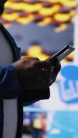 Vertical African American person engaged with mobile technology and multimedia feeds, showcasing the evolution of digital presence, communication and app interaction. Modern user interface. Camera B. video