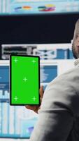 Vertical African american leader reviewing mockup screen with data insight for business development, surrounded by fintech charts and KPI projections. Financial performance and decision making. Camera A. video