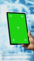 Vertical African american expert holds tablet with isolated screen next to cloud computing systems, focused on AI brain development and machine learning for innovation. Smart tech data science. Camera B. video