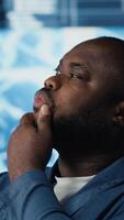 Vertical African American IT specialist examining artificial intelligence interface, showcasing machine learning algorithms through devices. High tech neural networks and data structures. Camera B. video