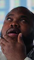 Vertical African american entrepreneur thinks about a new business vision for a strategy, evaluating infographics and financial reports with tech tools and analytics. Success and development. Camera B. video