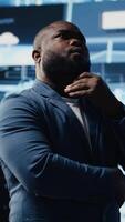 Vertical Black male specialist engaged in AI research interacting with data structures or platforms and smart technology systems. Studies deep learning, cloud computing and predictive analytics. Camera B. video