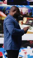 Vertical Young black person connecting to global social networks apps through mobile devices, opening platforms online on the dashboard. Communication and multitasking on social media. Camera A. video