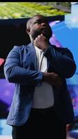 Vertical African American digital creator using dashboards with dynamic screens showcasing social media and networking, highlighting the importance of online engagement and global connection. Camera B. video