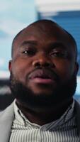 Vertical Young african american leader in high tech environment focused on graphs, strategic planning analysis for profitability and performance. Insightfulness and fintech forecasting. Camera B. video