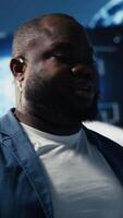 Vertical African american male specialist presenting deep learning AI systems, ensuring robotics for automation and neural networks brain innovation. Young professional presenter host. Camera B. video