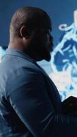 Vertical Tech savvy black engineer working with AI brain data visualization, illustrating computer science and automation tools for deep learning. Implementing neural networks systems. Camera B. video