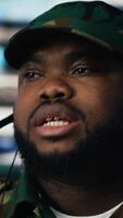 Vertical African american army personnel transmitting information on headset, gathering crucial enemy position data from satellite surveillance footage. Territorial guidance for a mission. Camera B. video