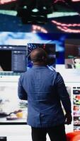 Vertical African american expert exploring tech driven environment with visual data, content feeds and applications. Symbolizing entertainment, social reach and digital transformation. Camera A. video