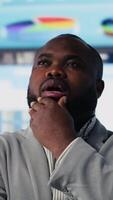 Vertical Black startup administrator thinking about new successful ideas to increase his funding and develop the business, using financial data and KPI projections for strategic decision making. Camera B. video