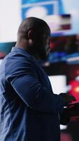 Vertical Black high tech person exploring digital world through web platforms, reflecting trends in social media, sharing and user interface design within online environment. Camera B. video