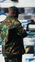 Vertical African american army staff monitoring drone and satellite imagery to collect information, finding enemy position helpful for war planning. National defense mission operations. Camera A. video