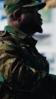 Vertical Military officer reviewing data from surveillance and works on tactical operations, tech driven mission control hub. Soldier uses threat detection electronic systems for national interests. Camera B. video