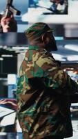 Vertical Military officer reviewing data from surveillance and works on tactical operations, tech driven mission control hub. Soldier uses threat detection electronic systems for national interests. Camera A. video